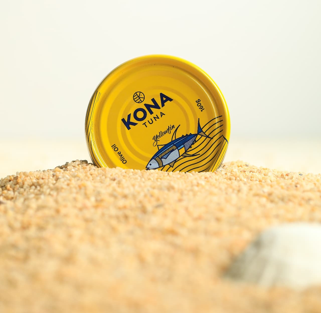 A stack of Kona sardine cans in sunflower oil and lemon on a bright yellow backdrop